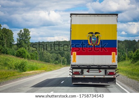 A  truck with the national flag of Ecuador depicted on the back door carries goods to another country along the highway. Concept of export-import,transportation, national delivery of goods 