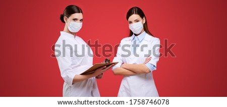Group of female doctors wearing medical protective mask and uniform holding tablet, young hospital staff, caucasian nurse