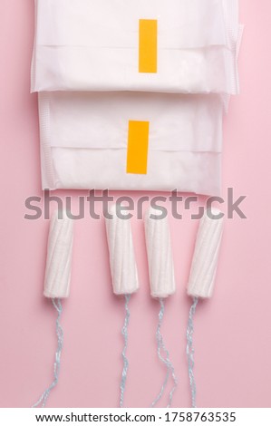 Menstrual cycle. Panty liners and swab on a pink background