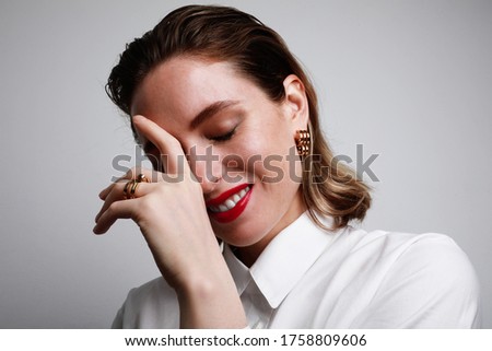 Happy attractive woman with red lips and smile at camera on grey background. Relationship and date concept.