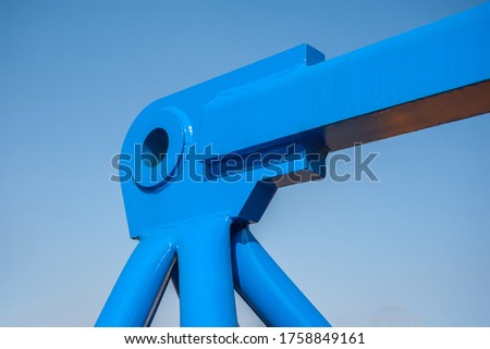 Blue metal crane construction on sky background