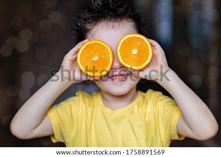A cheerful boy with oranges in his eyes. Fun and playful mood. Image with selective focus, noise effects.