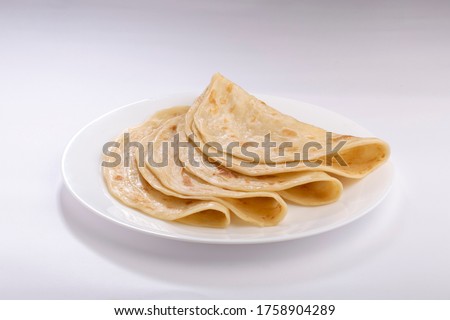 Homemade Kerala parotta/ porotta /paratta /layered flat bread using maida  or refined flour or all purpose flour beautifully arranged in a white plate with white background Royalty-Free Stock Photo #1758904289
