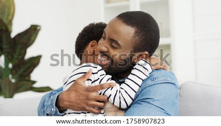 Portrait of African American dad hugging his cute little daughter. Happy Father's day. 