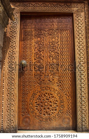 Cross on the wooden door of the temple, manual work. Tatev

