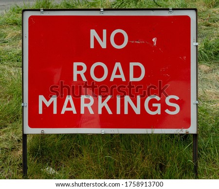 "NO ROAD MARKINGS" Temporary red road sign or pictogram on a lane in Worcestershire, England, UK