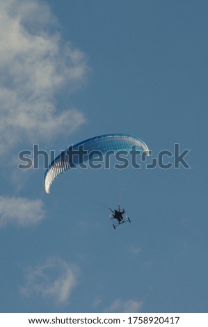 A paraglider on a flight in the clear sky 