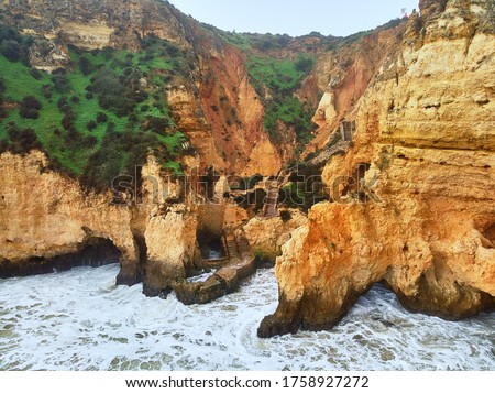 Aerial photo above view of Ponta da Piedade headland with group of rock formations yellow-golden cliffs along limestone coastline, Lagos town, most famous touristic attractions of Portugal