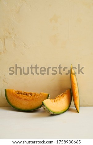 Fresh and bright Cantaloupe slices in pale yellow setting