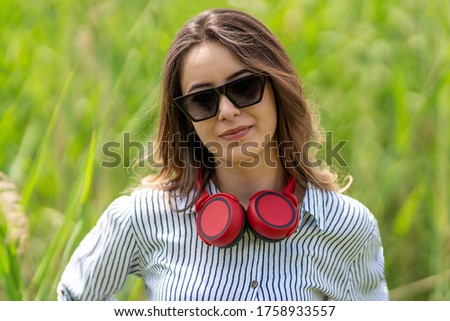 Portrait of young woman with red headphones