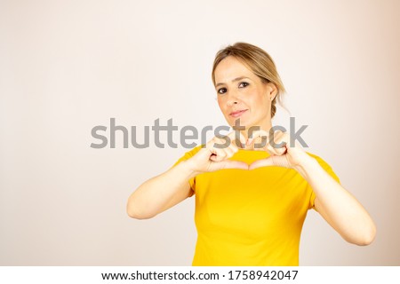Healthy beautiful woman making a heart gesture