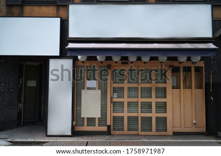 Traditional Japanese restaurants and shops style front view, Japanese wooden slide door. The blank banner and paper on the stand for advertisement,