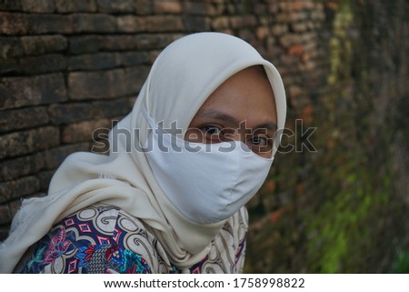 A Muslim woman wears a white mask when outdoors to cover the mouth from covid-19 spread