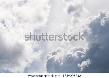 Gray and white fluffy clouds in the pale sky. Beautiful sky background