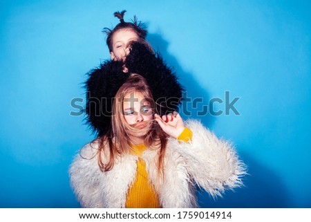 young and pretty fashion models boy and teenage girl posing cheerful on blue background, lifestyle people concept