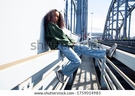 young cute teenage african girl in industrial zone happy smiling having fun, big city lifestyle fashion people