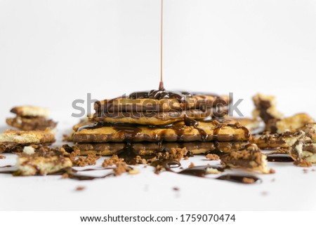 Biscuits and dripping melted chocolate on white background