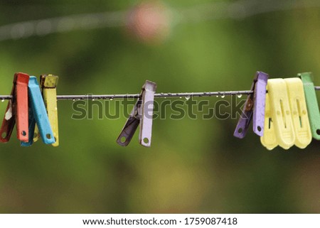 Colourful clothes clips and water drops hanging on cables. this photos clicked after rain