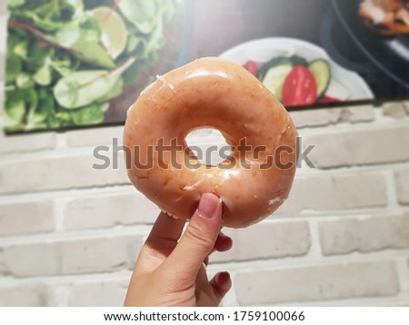 Picture of a hand holding original donuts