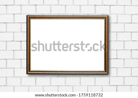 Old picture wooden frame on white brick wall in vintage room.