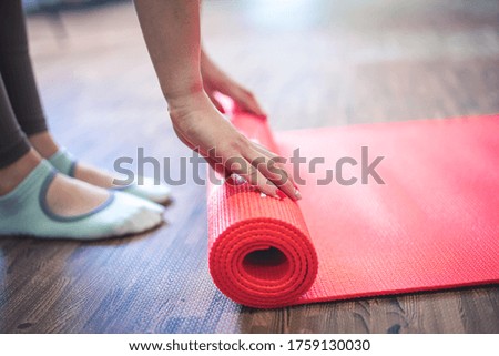 Cropped image of woman rolling yoga mat. Time for meditation. Healthy lifestyle.