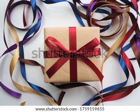 Top view of gift box with colorful ribbons on background