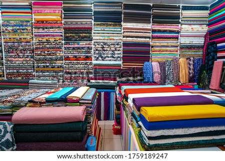 Colorful rolls of fabrics for sale in the market.Rolls of cotton with colorful and beautiful patterns in the shop selling fabrics as rolls of fabric that are woven with machines in the factory. Linens Royalty-Free Stock Photo #1759189247