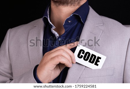 CODE text is written on the card that the businessman puts in his jacket pocket. Business concept.