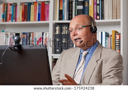 Lecturer at an online workshop with computer, camera and headset, webinar at a distance university, mooc, telelearning, e-learning Royalty-Free Stock Photo #175924238