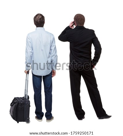 Back view of  two business men in suit pointing. Business team. traveling with suitcas. Rear view people collection. backside view of person. Isolated over white background.