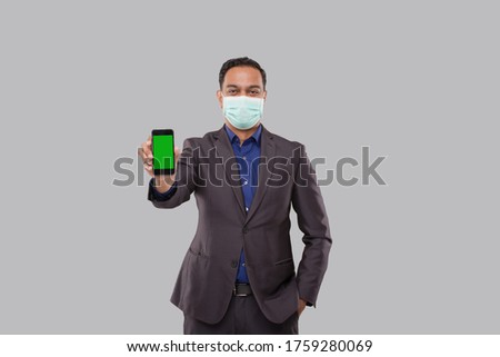 Businessman Showing Phone Wearing Medical Mask. Indian Business Man Technology Business at Home. Phone Green Screen Isolated