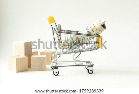 Studio shot fifty-dollar and twenty-dollar bills banknote and tiny shopping cart isolated on white