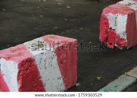 A stone on the road, painted red and white. Prohibition of moving