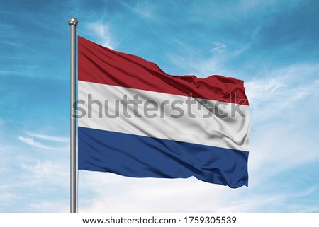 Netherlands national flag cloth fabric waving on beautiful sky.