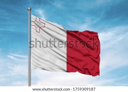 Malta national flag cloth fabric waving on beautiful sky.
