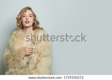 Nice woman in fur coat on white background
