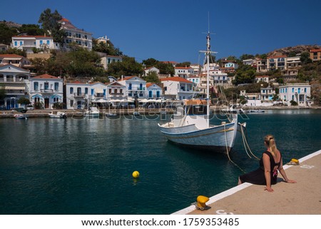 Woman relaxing at the enchanting port of Evdilos with view to white washed houses