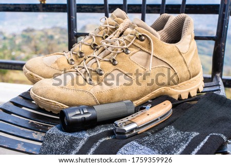Trecking or hiking equipment - boots, socks, folding knife and flashlight. Stock photo