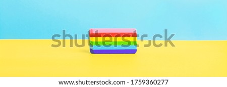 A multi colored eraser on a yellow and blue background. Colors of rainbow. Long banner. Back to school