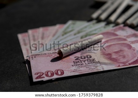 Turkish lira banknotes and cigarette on gray background