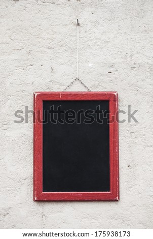 Blank school chalkboard, hanging on a wall.