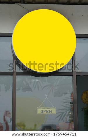 the circle nameplate is located at the top of the entrance. blank billboard, signboard mockup, ready to be designed. the nameplate shows an identity of the shop.