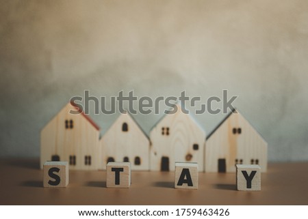 Wooden house with word stay. Safe home for safe life. Concept of self quarantine at home as preventative measure against virus outbreak and government-ordered confinement concept