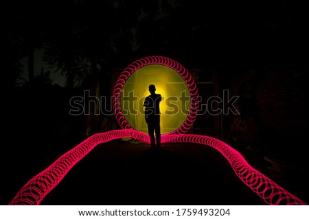 Sillhouette Indonesian people standing alone with beautiful circle light painting on the dark background