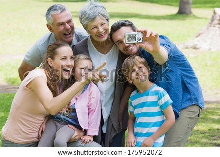 Man taking picture of his cheerful extended family at the park