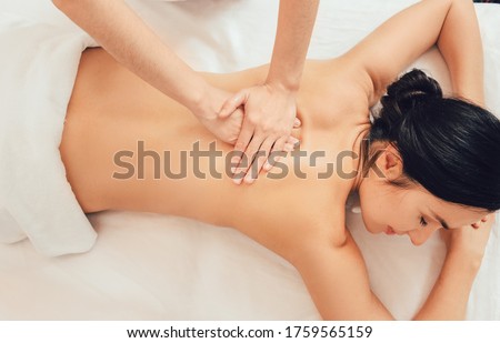 Relaxing back massage, massage therapist massages the back of a beautiful woman, relieve muscle tension back, top view Royalty-Free Stock Photo #1759565159