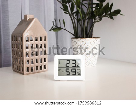 Thermometer hygrometer measuring the optimum temperature and humidity in a house, a photo for articles about the house’s microclimate, health, disease relief and virus treatment Royalty-Free Stock Photo #1759586312