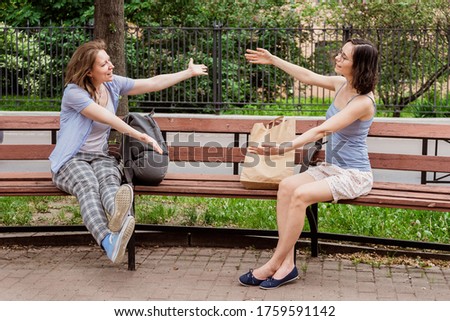 Friends hug each other in the air. Greeting girls with social distancing