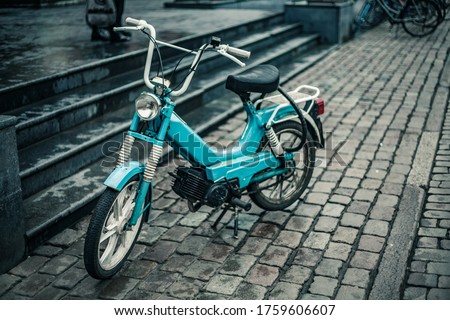 A retro bike parked up on a cobblestone pavement 