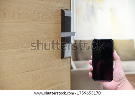 Hotel door security Unlocking by application on mobile phone. Digital door lock, key less system of access door. Close up and selective focus.